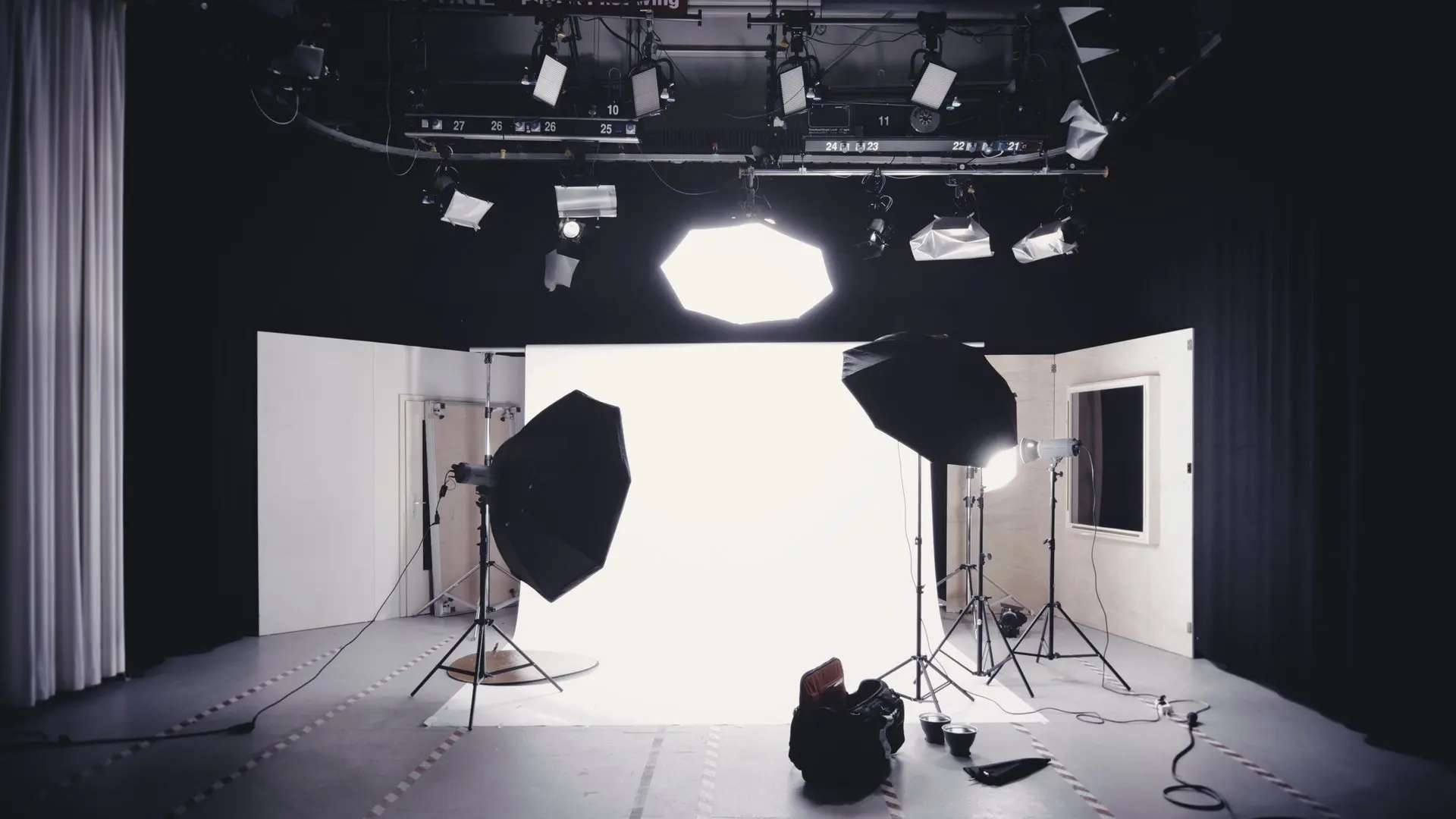 Un studio photo éclairé par des boîtes à lumière, devant un fond blanc.